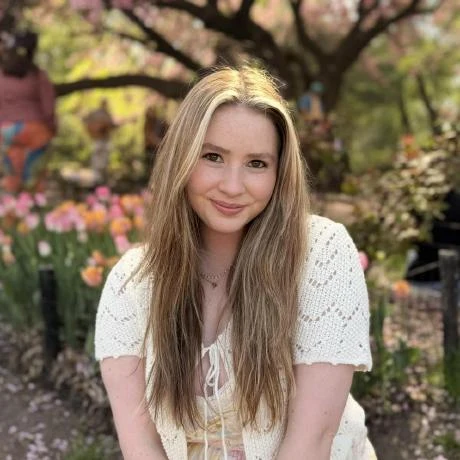 Haylee Pulisciano smiling in a garden among flowers